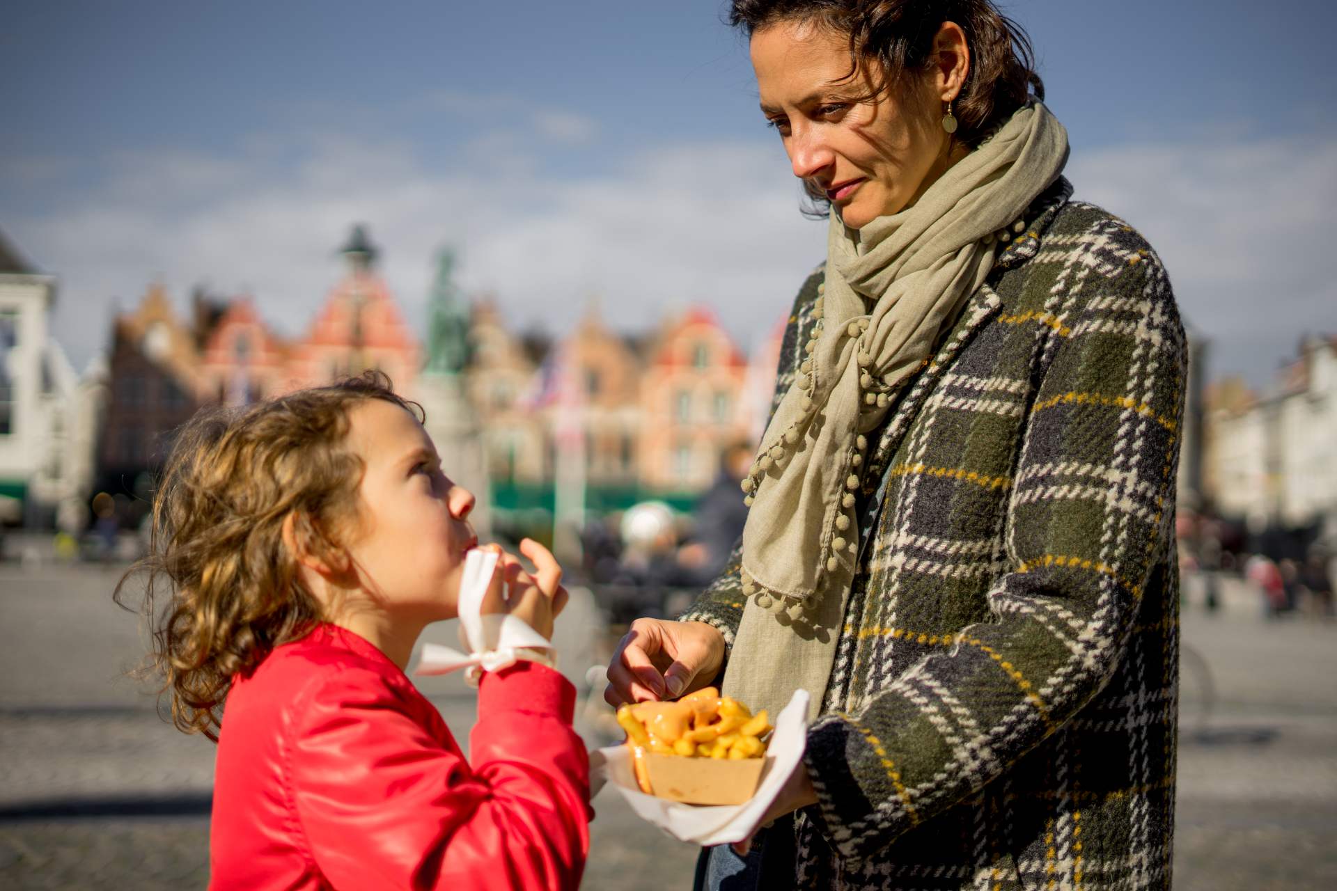 Mother and daughter ating Belgian fries at the market square